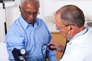 Doctor taking blood pressure of older man